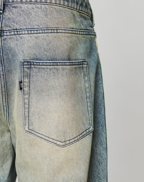 Close-up of the back pocket of LIVE FAST DIE YOUNG’s Rhomb Wide Denim in light blue, slightly faded 100% Baumwolle, featuring visible stitching, Diamond-Shape Panels, and a small black tag on the pocket side.