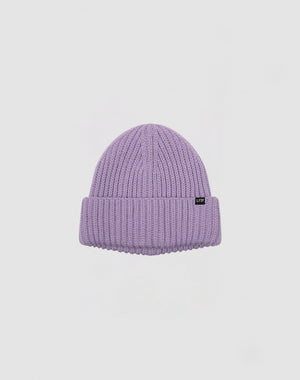 The LIVE FAST DIE YOUNG Rib Knit Beanie is a light purple Polyacryl beanie with a ribbed knit, folded brim, and a small black rectangular tag on the front, shown on a plain white background.