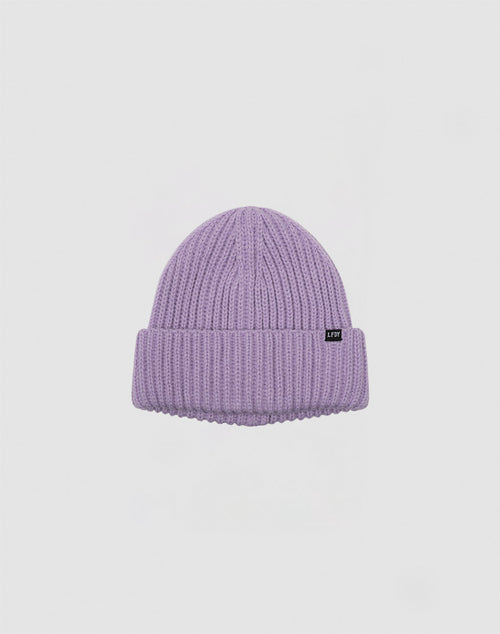 The LIVE FAST DIE YOUNG Rib Knit Beanie is a light purple Polyacryl beanie with a ribbed knit, folded brim, and a small black rectangular tag on the front, shown on a plain white background.