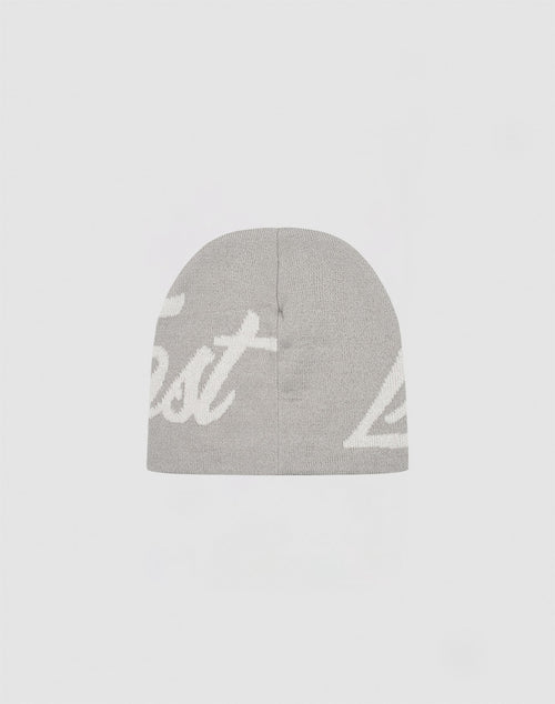 The LFDY Jacquard Beanie by LIVE FAST DIE YOUNG is a gray, 100% Polyacryl knit hat featuring white, partially visible “Logo Strick” cursive lettering on the front, shown against a simple light background.