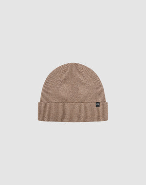 The Live Fast Boucle Beanie by LIVE FAST DIE YOUNG is a light brown ribbed polyester beanie with a folded brim and a small black flag-label on the front, shown against a plain light gray background.