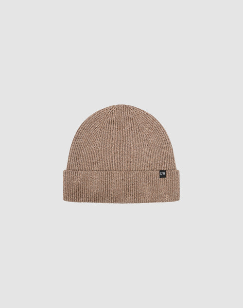 The Live Fast Boucle Beanie by LIVE FAST DIE YOUNG is a light brown ribbed polyester beanie with a folded brim and a small black flag-label on the front, shown against a plain light gray background.