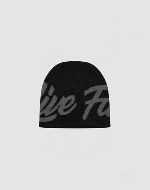 The LFDY Jacquard Beanie by LIVE FAST DIE YOUNG features black polyacryl fabric with a large, subtle gray script design on the front, shown against a light gray background.