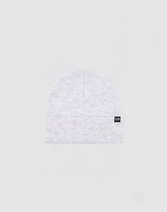 The LIVE FAST DIE YOUNG Basic Beanie is a light gray Polyacryl knit, one size, with a folded cuff and a small black rectangular flaglabel with white text on the cuff, shown against a plain light background.