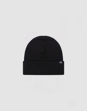 The LIVE FAST DIE YOUNG Basic Beanie is plain black, made from 100% cotton, features a folded brim and a small rectangular side tag. Presented on a light gray background. Care: Gentle washing recommended.