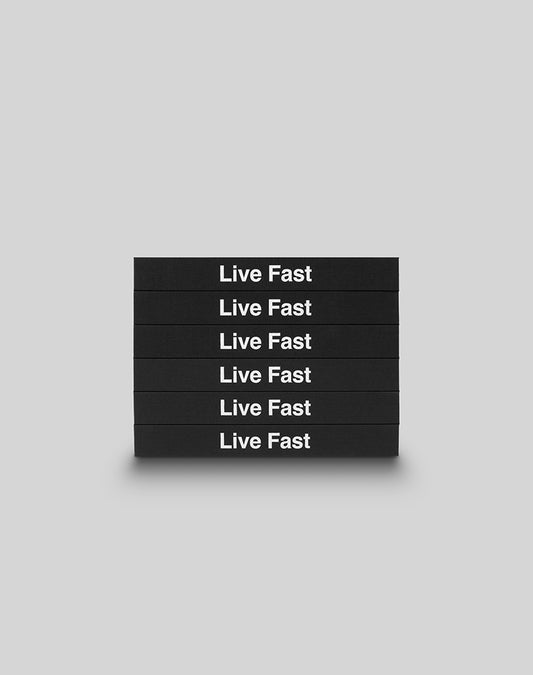 Six black hardcover LFDY Brand Bible books from LIVE FAST DIE YOUNG are stacked horizontally, each boldly displaying Live Fast in white letters against a plain light gray background.
