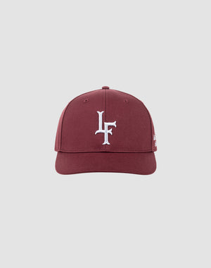 The LF Snapback by LIVE FAST DIE YOUNG is a maroon cotton baseball cap featuring a white LF logo embroidered on the front, shown against a light gray background. It includes a snap closure for an adjustable fit.