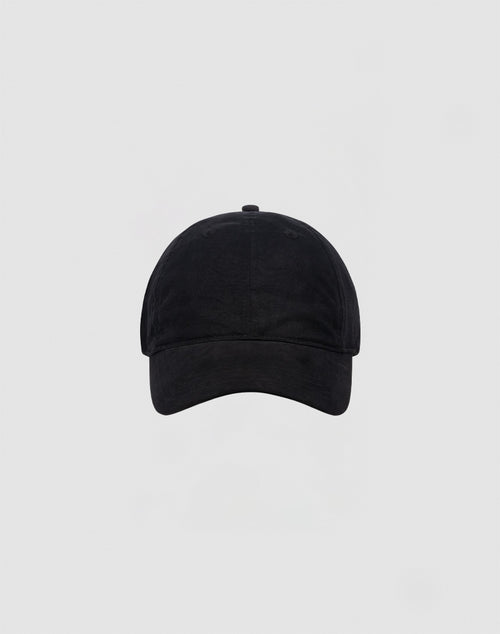 The LIVE FAST DIE YOUNG Basic Cap, a plain black baseball cap with curved brim and visible stitching, is centered on a light gray background. It features praktische Verstellbarkeit durch Klettverschluss and no visible logos or designs.