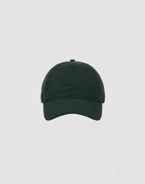 A front view of the LIVE FAST DIE YOUNG Basic Cap, a plain dark green polyester baseball cap with a Klettverschluss, set against a light grey background.