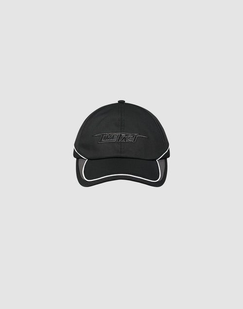The LIVE FAST DIE YOUNG Live Fast 3000 Cap is a black polyester baseball cap with white trim, an embroidered Logo-Stick on the front, and a Klettverschluss at the back, shown against a light gray background.