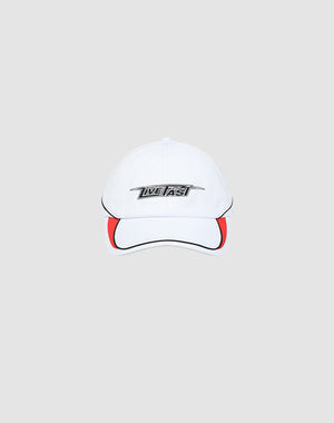 The Live Fast 3000 Cap by LIVE FAST DIE YOUNG is a white baseball cap with black piping, a red brim accent, and LIVE FAST in bold on the front. Features an adjustable Klettverschluss. Shown on a light gray background.