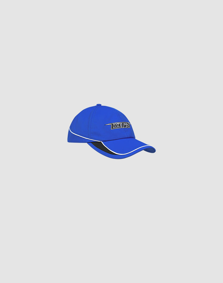 The Live Fast 3000 Cap by LIVE FAST DIE YOUNG is a royal blue polyester baseball cap with a curved brim, white trim, black underbrim, and LIVETS Logo-Stick text on the front. Shown against a plain light grey background.