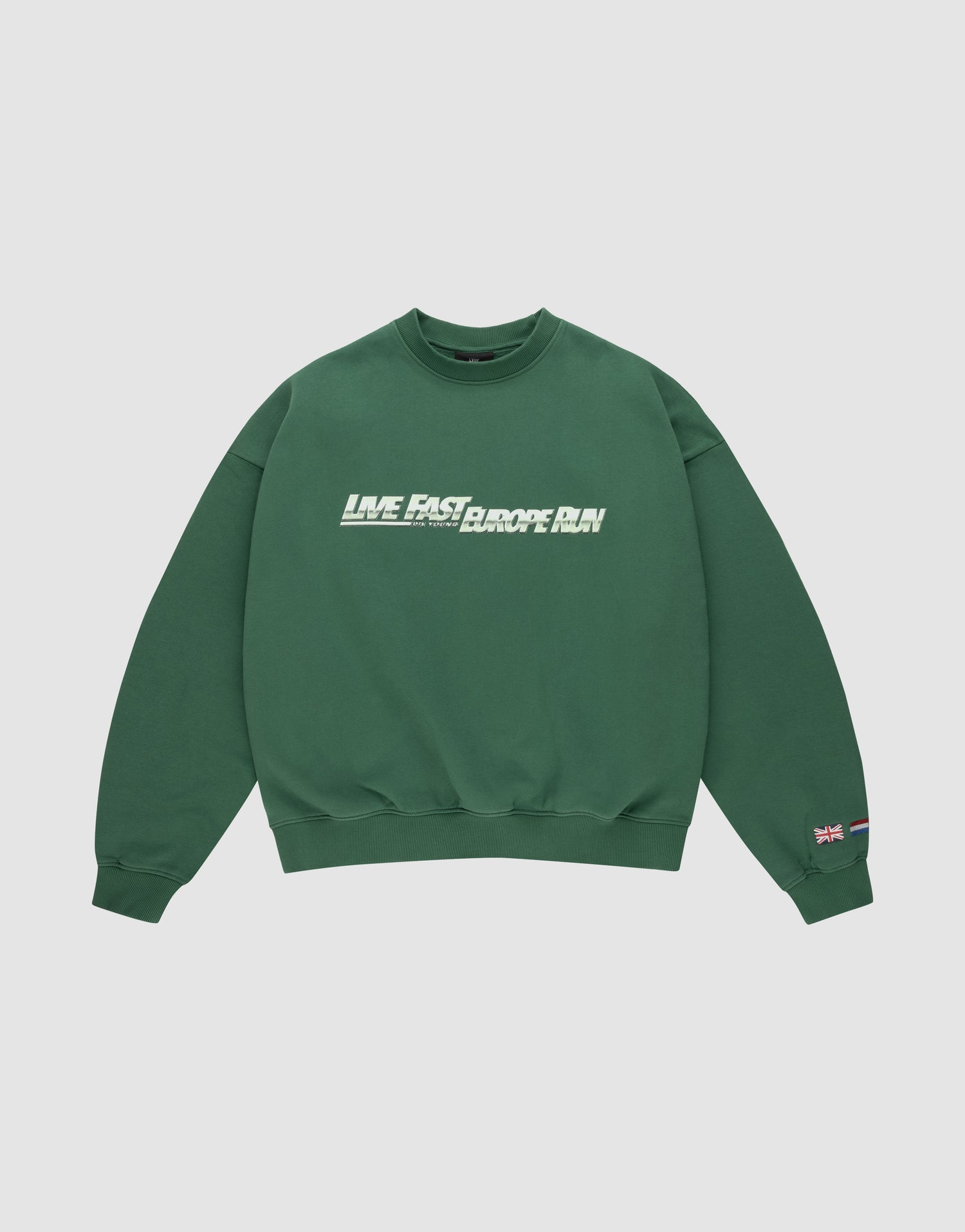 The LFDY Europe Run Sweater by LIVE FAST DIE YOUNG is a forest green oversized crewneck with “LIVE FAST, RACE RUN” in bold white and green front print and small flag patches on the left sleeve near the cuff. Made from soft Baumwolle. | plain