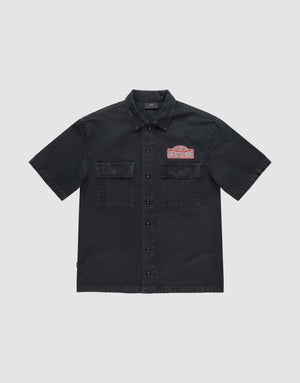 The LFDY Workwear Shirt by LIVE FAST DIE YOUNG is an oversized, short-sleeve black button-up with two chest pockets, LFDY branding, and a red and white embroidered Undestroyed patch on the left chest, shown on a light grey background. | plain