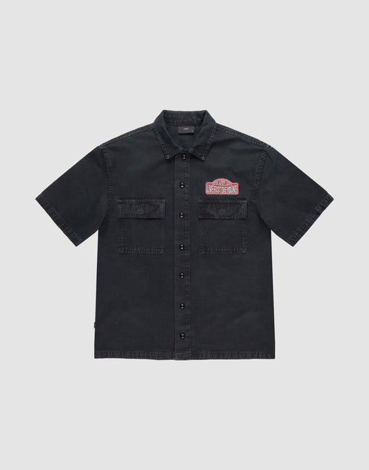 The LFDY Workwear Shirt by LIVE FAST DIE YOUNG is an oversized, short-sleeve black button-up with two chest pockets, LFDY branding, and a red and white embroidered Undestroyed patch on the left chest, shown on a light grey background. | plain
