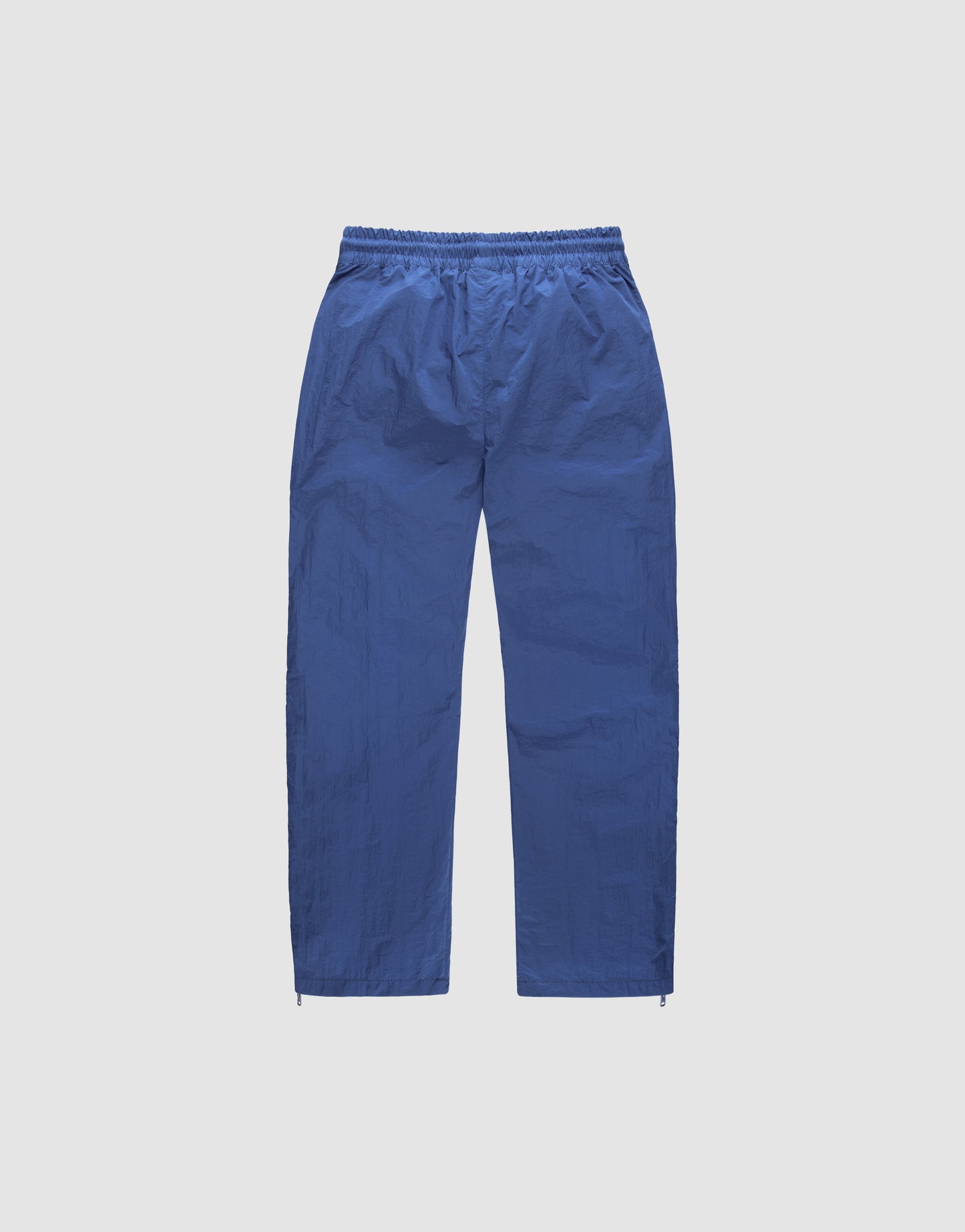 LIVE FAST DIE YOUNG Zip Tape Track Pants—loose-fitting blue pants with an elastic waistband, straight legs, and a two-way zipper, shown flat on a white background.