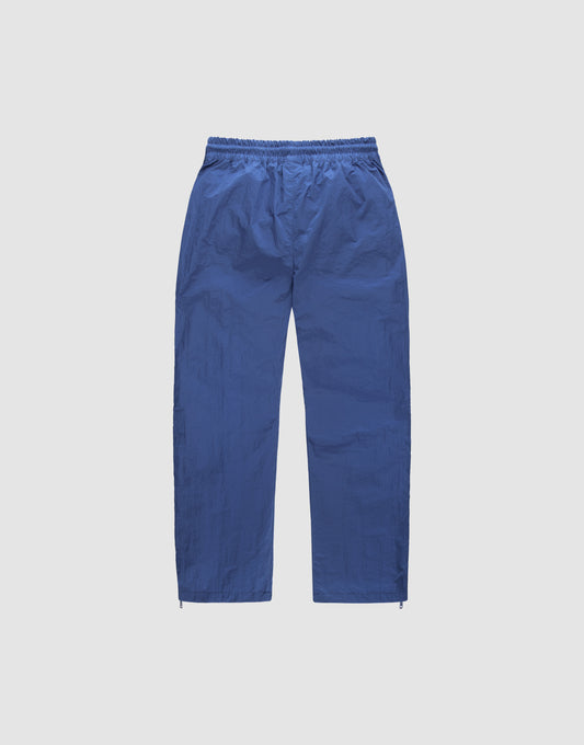 LIVE FAST DIE YOUNG Zip Tape Track Pants—loose-fitting blue pants with an elastic waistband, straight legs, and a two-way zipper, shown flat on a white background.