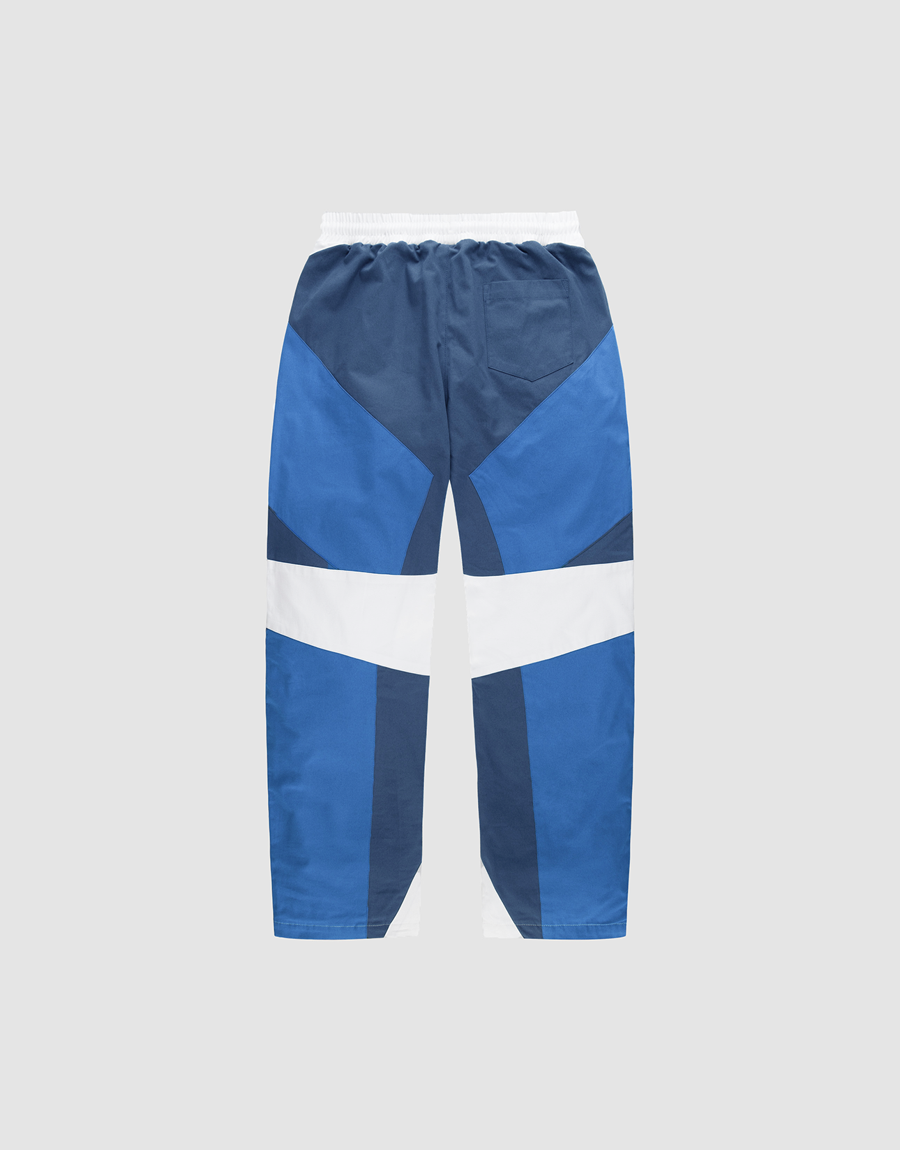 The LFDY Cross Pants by LIVE FAST DIE YOUNG feature an oversized fit, elastic waistband, and colorblock geometric panels in navy blue, royal blue, and white with wide legs, shown on a plain light background.