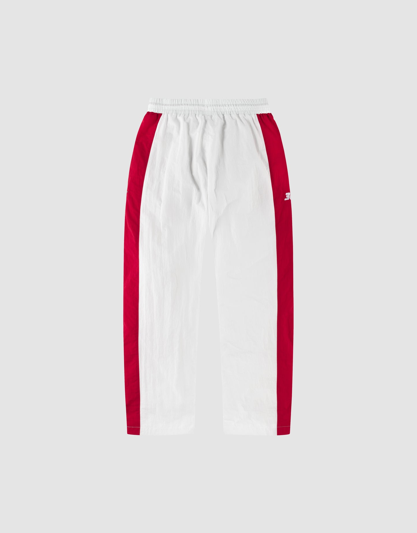 The LFDY Trackpants 3000 by LIVE FAST DIE YOUNG feature a wide fit, white color with bold red side panels, elastic waistband, and zip pockets, shown against a plain light gray background.