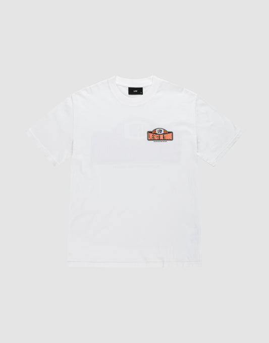 The Live Fast 2013 Tee by LIVE FAST DIE YOUNG is a plain white regular-fit short-sleeve t-shirt with topstitching and a small rectangular LH5 MERCH TOUR patch on the left chest. Made from 100% Baumwolle. Shown on a light gray background.