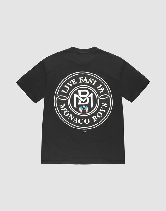 The LFDY Monaco Boys Tee by LIVE FAST DIE YOUNG features an oversize black fit, a bold white circular logo with "LIVE EAST DY MONACO BOYS" and three shields on the back, "LIFT" near the hem, and is made of 100% cotton. | plain