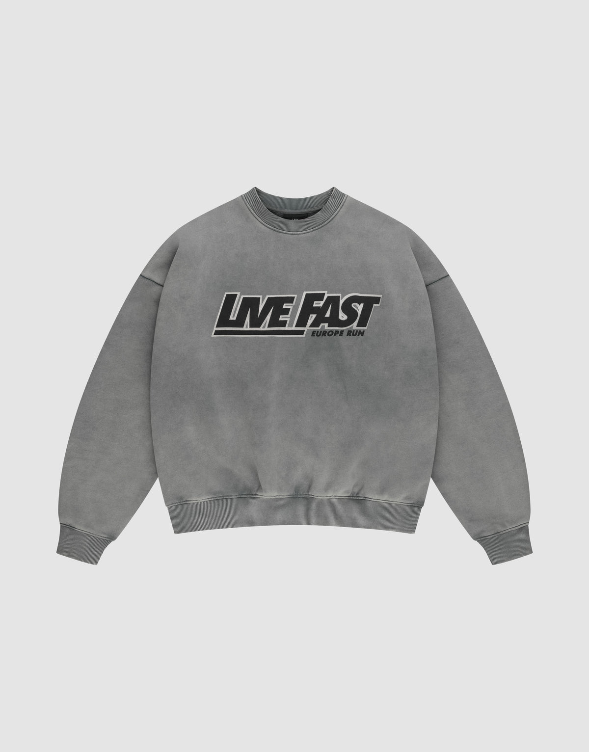 The LIVE FAST DIE YOUNG Live Fast Europe Run Sweater is a gray oversized crewneck with bold black and white "LIVE FAST" and "EUROPE RUN" text, ribbed cuffs/hem, vintage wash, and crafted from Baumwolle for a relaxed look. | plain