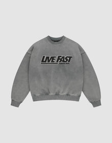 The LIVE FAST DIE YOUNG Live Fast Europe Run Sweater is a gray oversized crewneck with bold black and white "LIVE FAST" and "EUROPE RUN" text, ribbed cuffs/hem, vintage wash, and crafted from Baumwolle for a relaxed look. | plain