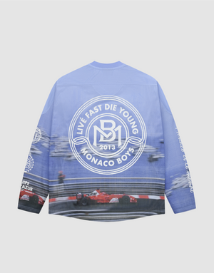 The LFDY Yacht Jersey by LIVE FAST DIE YOUNG is a blue oversize long-sleeve shirt with racing car and track graphics on the back, a large white circular logo, and additional white graphics on the sleeves and lower back. | plain