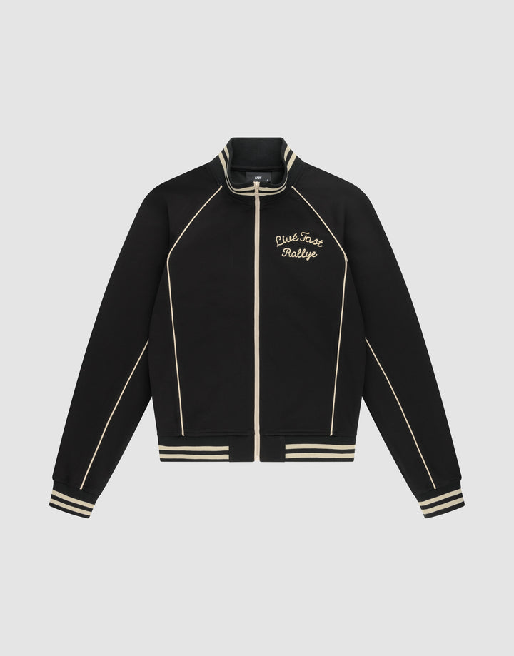 The Live Fast Tracksuit Jacket by LIVE FAST DIE YOUNG is a black jacket with cream piping, striped cuffs and hem, and a Chainstitch Live Fast Rallye logo on the left chest. Made from Baumwolle Polyester with a regular fit, it has a full zip and stand-up collar. | plain