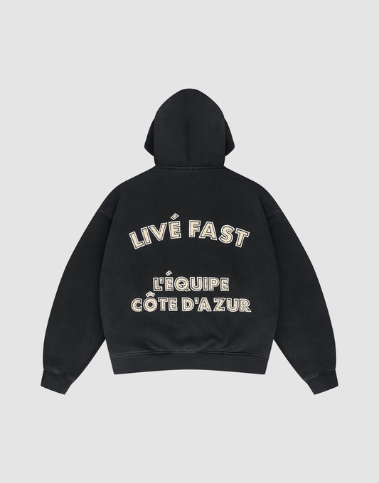 The LFDY L'Équipe Hooded Zip by LIVE FAST DIE YOUNG is a black oversize hoodie with LIVE FAST and LÉQUIPE CÔTE DAZUR in bold white lettering on the back, plus a soft waffle lining for extra comfort. | plain