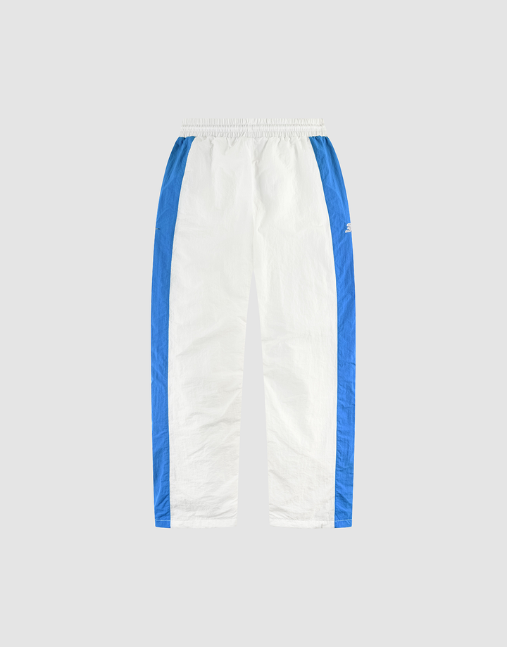 The LFDY Trackpants 3000 by LIVE FAST DIE YOUNG feature white fabric with blue side panels, an elastic waistband, side pockets, and a small logo on the upper left leg, shown against a plain light gray background.
