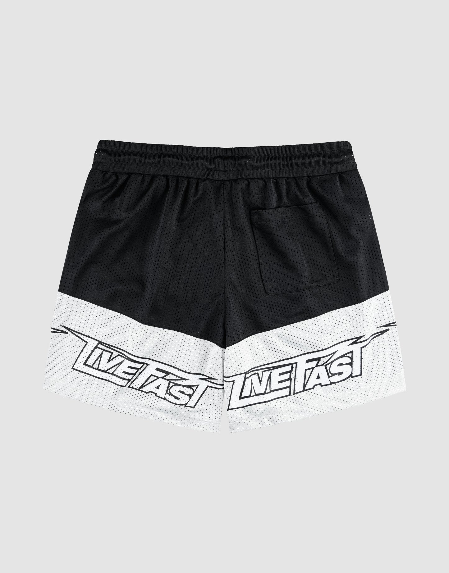 The LFDY Racing Mesh Shorts by LIVE FAST DIE YOUNG are black and white athletic shorts with a wide elastic waistband, back pocket, and large "LIVE FAST" prints on the lower white section of both legs. Background is plain light gray.