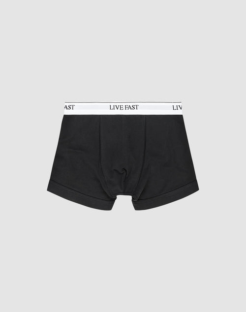 LIVE FAST DIE YOUNG Live Fast Trunks (2 Pack): Black mens boxer briefs made from cotton, with a white elastic waistband featuring LIVE FAST in black text, shown on a plain light gray background.