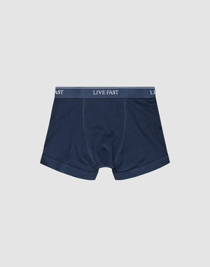 LIVE FAST DIE YOUNGs Live Fast Trunks (2 Pack) feature navy blue mens boxer briefs in a Regular Fit, made from soft cotton with a thick waistband displaying LIVE FAST in white. Shown laid flat on a plain white background.