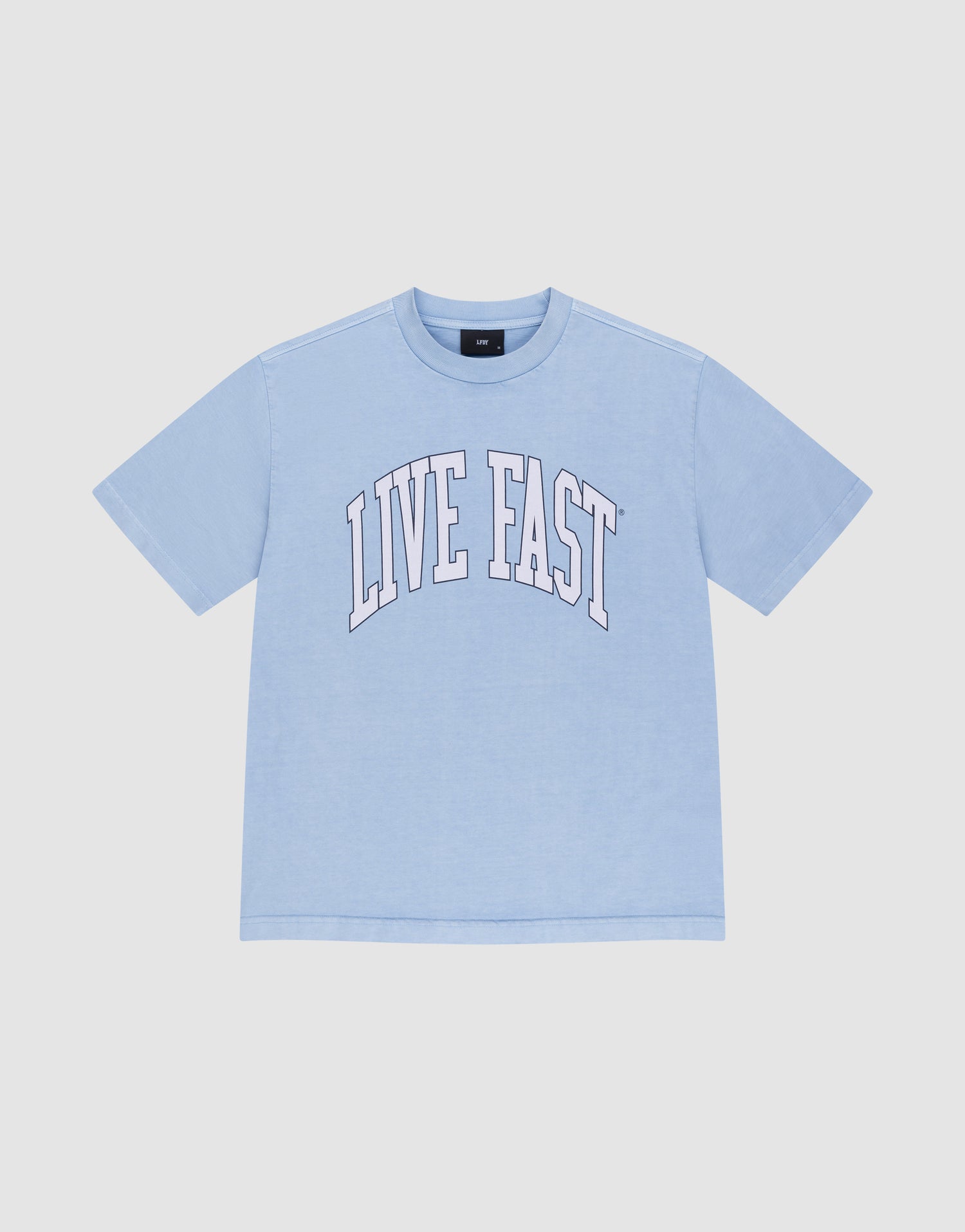 The LIVE FAST DIE YOUNG Live Fast College Tee is a light blue, 100% Baumwolle oversize short-sleeve shirt with "LIVE FAST" in large white arched letters on the front, shown on a plain white background. | plain