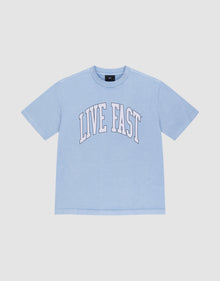 The LIVE FAST DIE YOUNG Live Fast College Tee is a light blue, 100% Baumwolle oversize short-sleeve shirt with "LIVE FAST" in large white arched letters on the front, shown on a plain white background. | plain