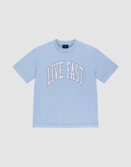 The LIVE FAST DIE YOUNG Live Fast College Tee is a light blue, 100% Baumwolle oversize short-sleeve shirt with "LIVE FAST" in large white arched letters on the front, shown on a plain white background. | plain
