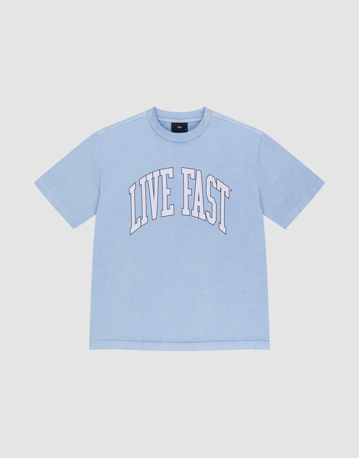 The LIVE FAST DIE YOUNG Live Fast College Tee is a light blue, 100% Baumwolle oversize short-sleeve shirt with "LIVE FAST" in large white arched letters on the front, shown on a plain white background. | plain