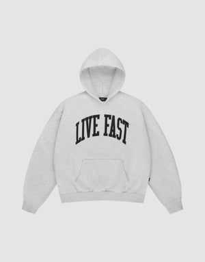 The LIVE FAST DIE YOUNG Live Fast College Hooded is a light gray hoodie with bold black "LIVE FAST" lettering across the chest, long sleeves, and a front pocket, shown on a plain white background. | plain