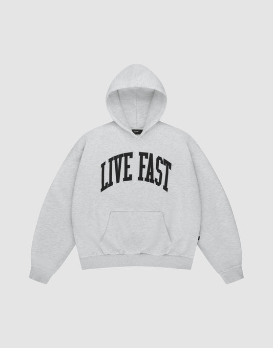 The LIVE FAST DIE YOUNG Live Fast College Hooded is a light gray hoodie with bold black "LIVE FAST" lettering across the chest, long sleeves, and a front pocket, shown on a plain white background. | plain