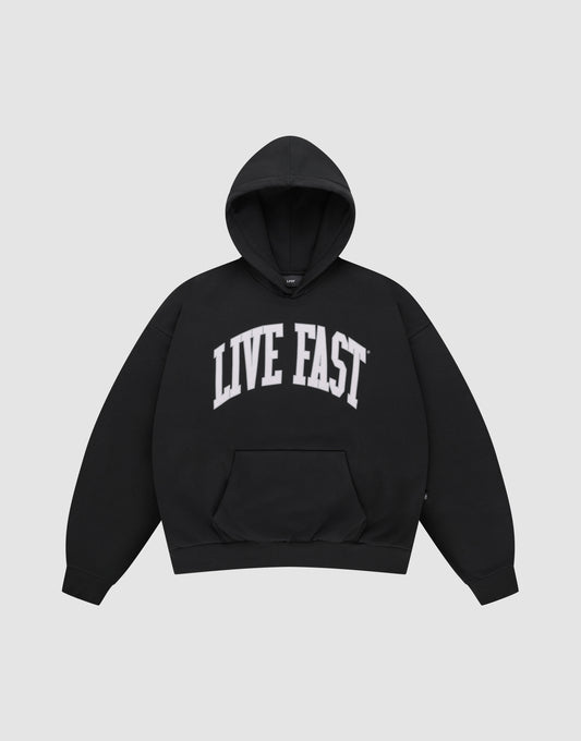 The LIVE FAST DIE YOUNG "Live Fast College Hooded" is a black, oversized cotton pullover featuring a front pocket and bold white “LIVE FAST” print across the chest. | plain