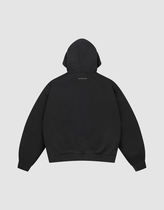 The LIVE FAST DIE YOUNG Live Fast College Hooded is an oversized black sweatshirt, shown from the back with a small white text logo below the hood, made from premium cotton against a plain light gray background.