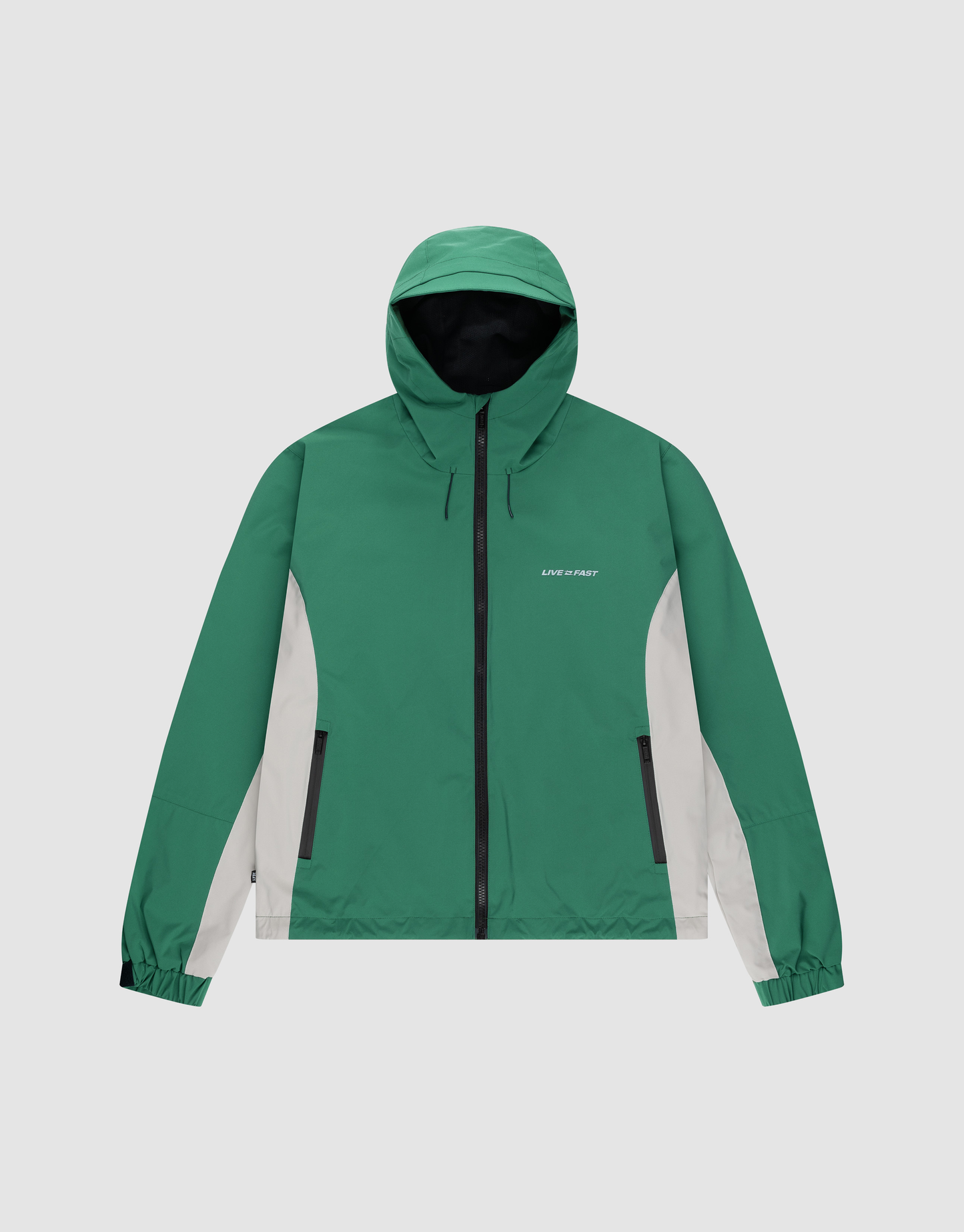 The LIVE FAST DIE YOUNG Basic Shell Jacket is green and white with a black, wasserabweisender Reißverschluss, elastic cuffs, white side panels, zippered pockets, LOW SPIRIT on the left chest, and an Oversize Fit for comfort.