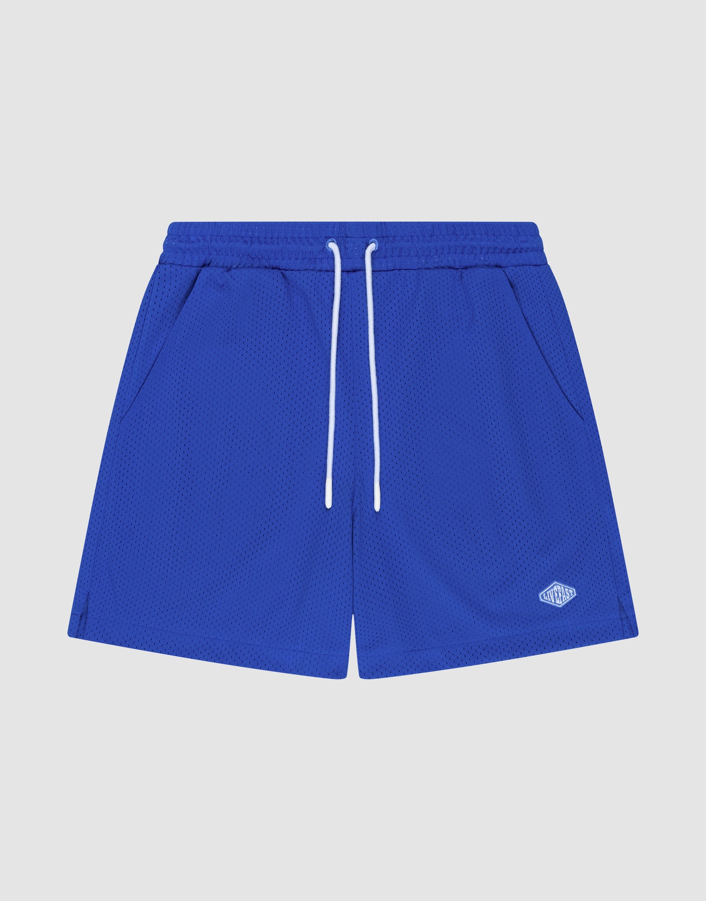 LIVE FAST DIE YOUNG Basic Mesh Shorts in royal blue polyester with an elastic waistband, white drawstrings, side pockets, and a small white embroidered logo on the bottom left leg, shown on a plain white background.