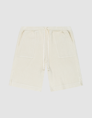 Die Basic Knit Shorts von LIVE FAST DIE YOUNG in Beige aus gerippter Baumwolle haben einen elastischen Bund mit Kordelzug, zwei aufgesetzte Taschen und sind knielang. Das Modell ist flach auf weißem Hintergrund ausgebreitet. | plain