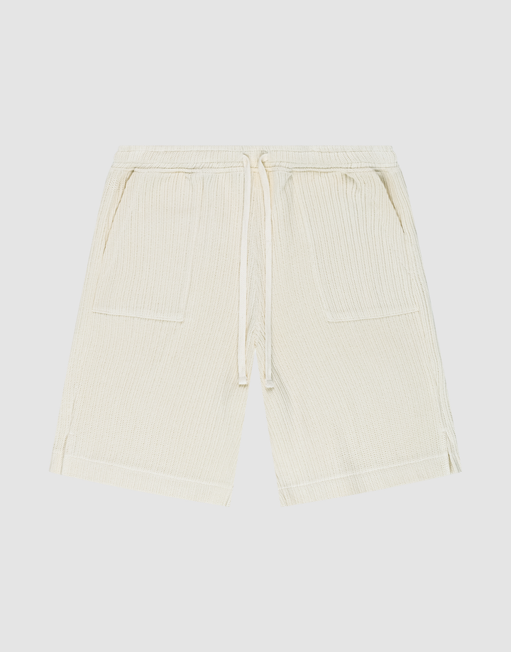 Die Basic Knit Shorts von LIVE FAST DIE YOUNG in Beige aus gerippter Baumwolle haben einen elastischen Bund mit Kordelzug, zwei aufgesetzte Taschen und sind knielang. Das Modell ist flach auf weißem Hintergrund ausgebreitet. | plain