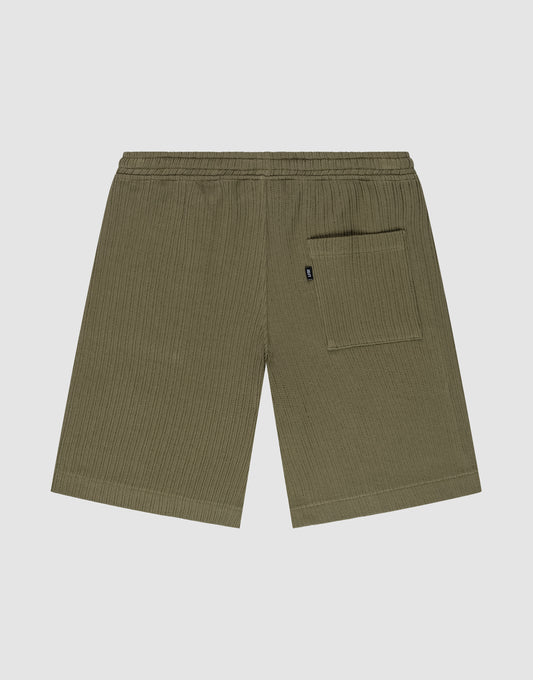 Die Basic Knit Shorts von LIVE FAST DIE YOUNG in Olivgrün sind aus Baumwolle gefertigt, haben einen elastischen Bund, eine einzelne Gesäßtasche rechts und werden flach auf einem hellgrauen Hintergrund präsentiert.