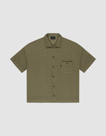 Olive green Basic Knit Shirt by LIVE FAST DIE YOUNG, oversize fit with short sleeves, textured fabric, and a single left chest pocket with a small black tag; shirt is laid flat on a light background. | plain