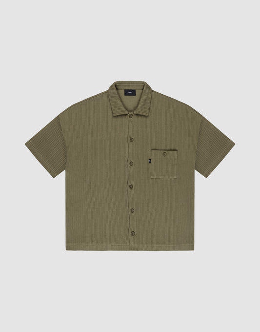Olive green Basic Knit Shirt by LIVE FAST DIE YOUNG, oversize fit with short sleeves, textured fabric, and a single left chest pocket with a small black tag; shirt is laid flat on a light background. | plain