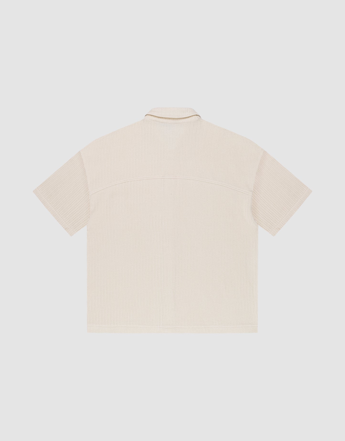 Back view of the LIVE FAST DIE YOUNG Basic Knit Shirt in light beige, featuring short sleeves, Hemdkragen, subtle textured pattern, Oversize Fit, and straight hem. Displayed against a plain white background.